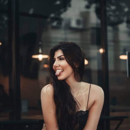 Woman Sitting by the Glass Window Sticking Out Tongue