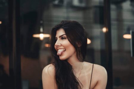 Woman Sitting by the Glass Window Sticking Out Tongue