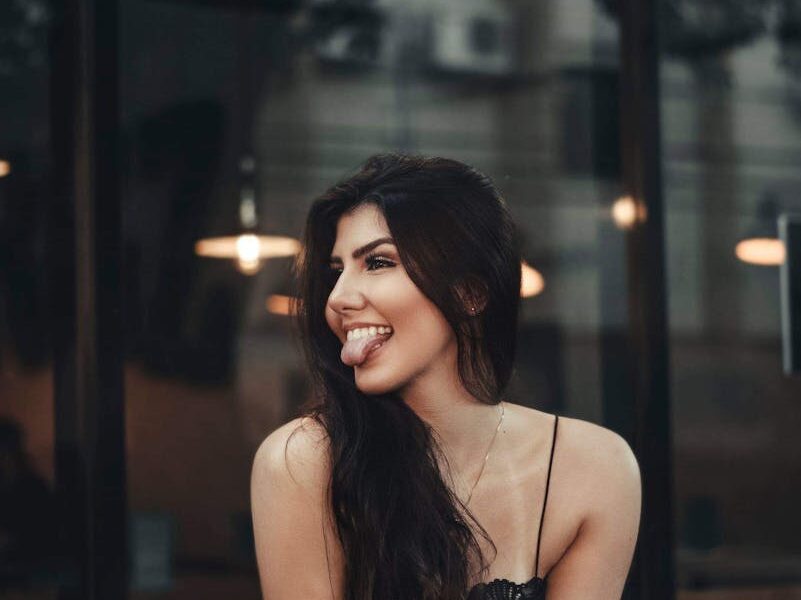 Woman Sitting by the Glass Window Sticking Out Tongue